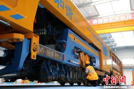 圖為工人正在清理大型養(yǎng)路機械?！堖h(yuǎn) 攝